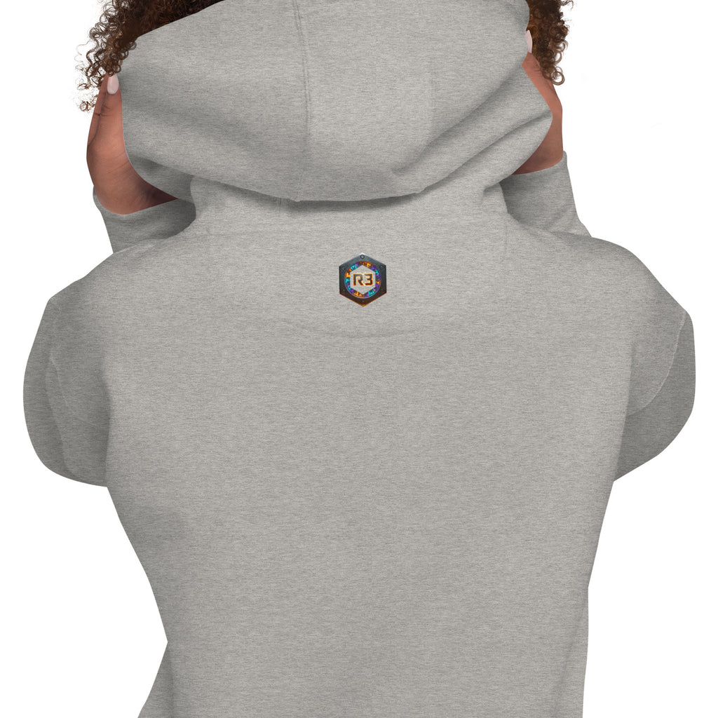 Woman wearing a light gray hoodie with a R3 logo on the back exterior tag.