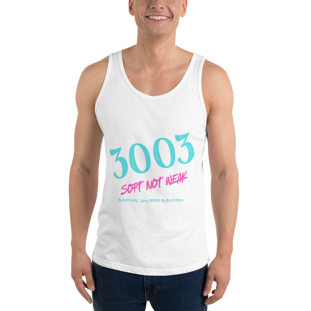 A man wearing a white tank top with a graphic print that reads '3003 SOFT NOT WEAK' in teal and pink text, paired with dark blue jeans.