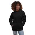 Woman wearing a black hoodie with Let Them on front left chest.