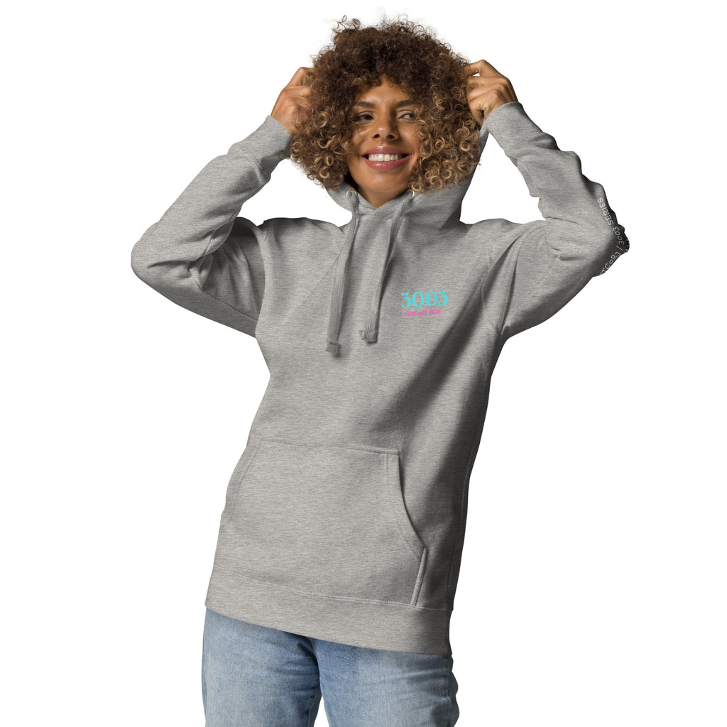 Woman wearing a light gray hoodie with 3003 Soft Not Weak text on front left chest.