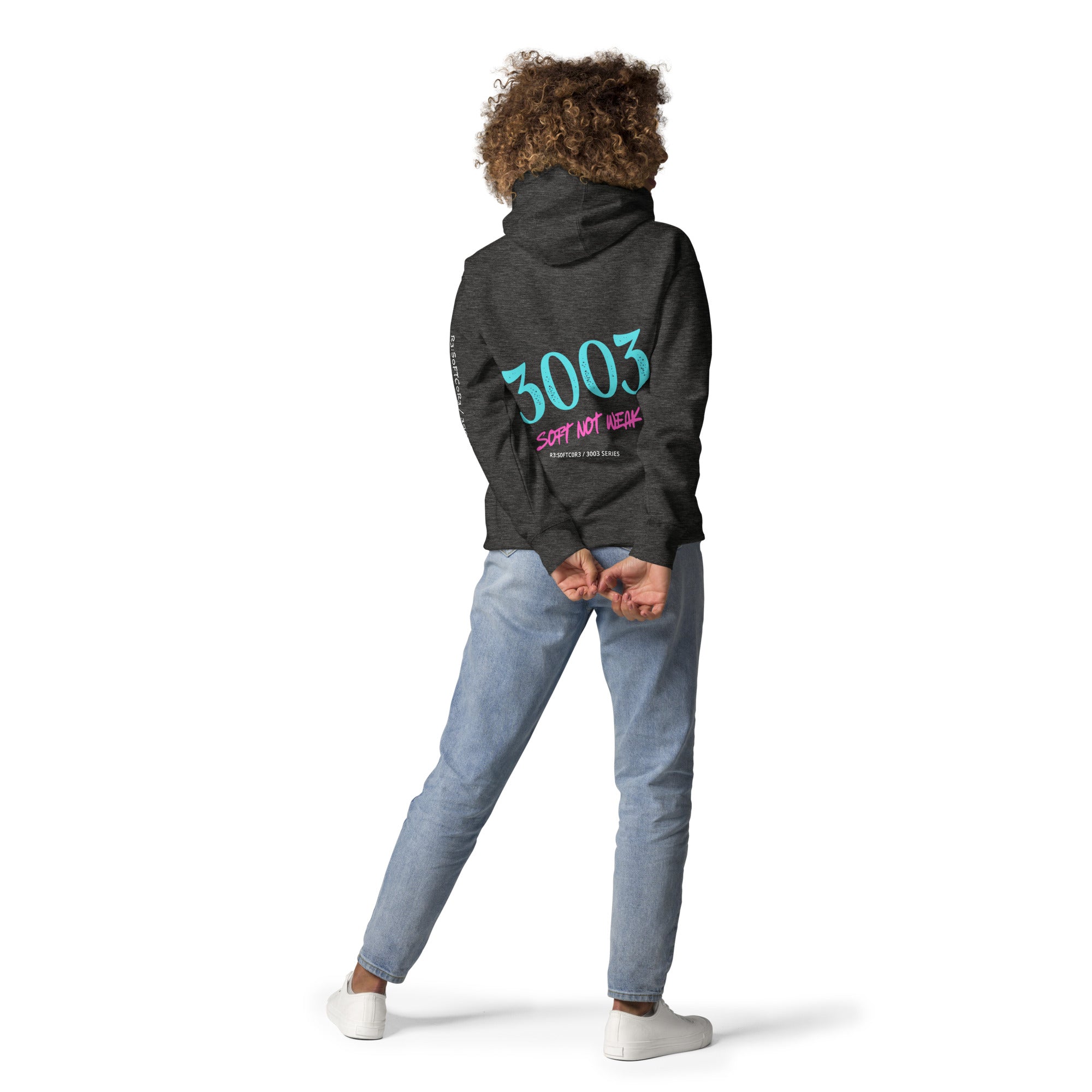 Woman wearing a dark gray hoodie with  3003 SOFT NOT WEAK R3:S0FTC0R3 / 3003 Series | R3:BU1LT' on the back.