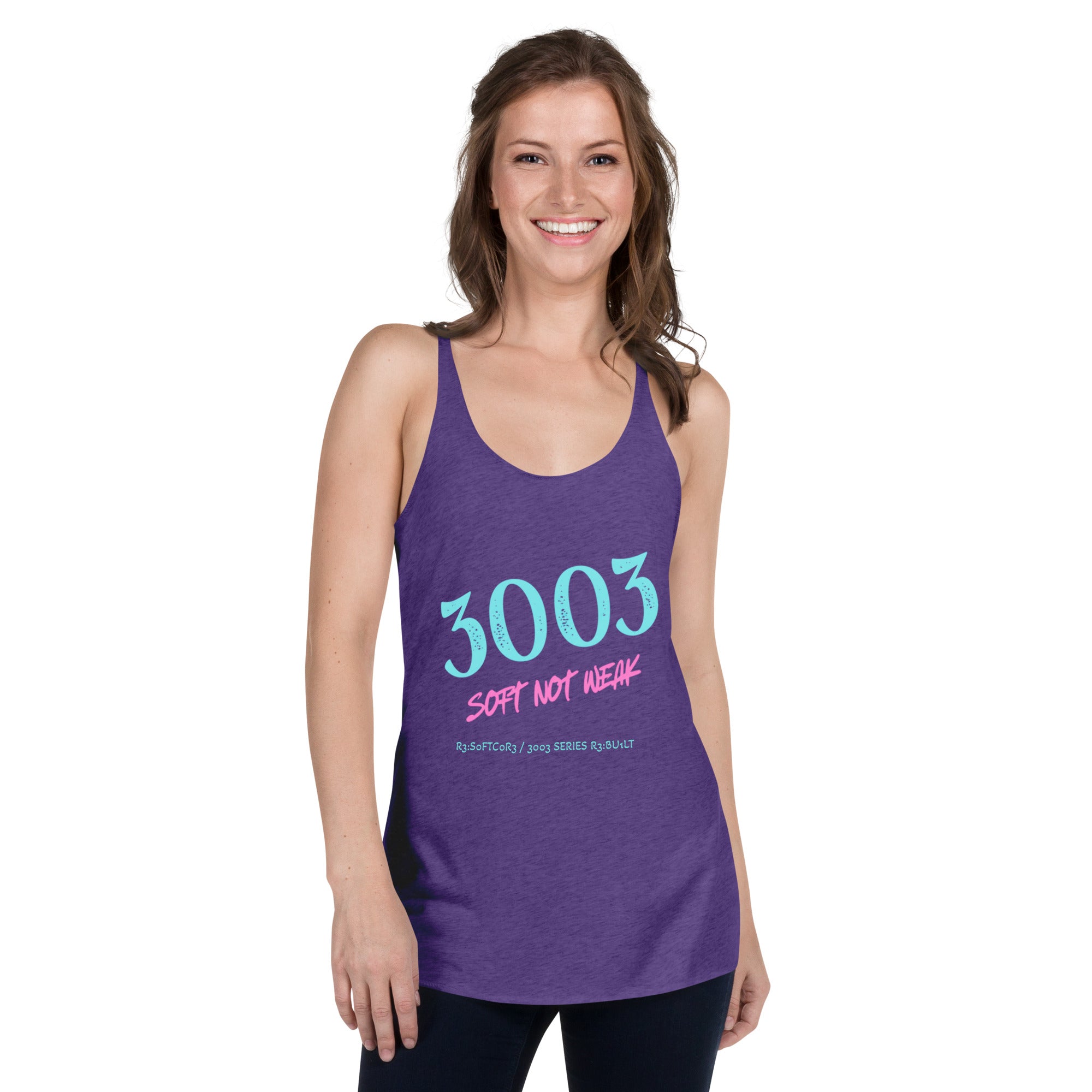 A woman modeling a purple racerback tank top with a graphic that reads '3003 SOFT NOT WEAK' in light blue and pink text.